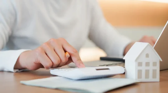 Conseiller bancaire expliquant un dossier de crédit immobilier à un couple de clients dans une agence bancaire française
